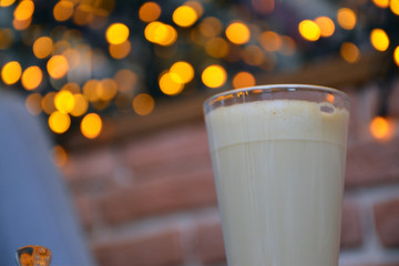  Aromatic coffee with a pattern in a glass cup on a brick wall background.