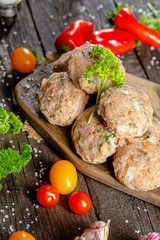 homemade meatballs, cutlets raw from red and white fish meat, in a vintage rustic plate bowl, fork...