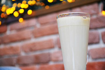  Aromatic coffee with a pattern in a glass cup on a brick wall background.