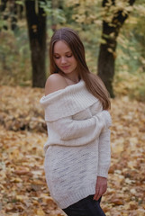 Portrait of a beautiful, dreamy and happy girl with long wavy hair in knit sweater autumn. Nice weather