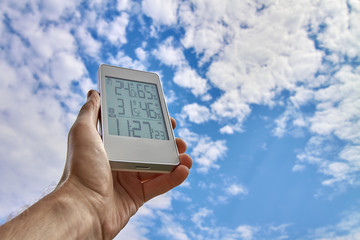 Best personal weather station device with weather conditions inside and outside. A man holds a...
