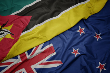 waving colorful flag of new zealand and national flag of mozambique.