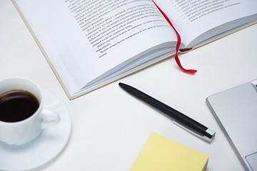 Office desk laptop computer, notebook paper, pencil, book and espresso coffee on white table workspace top view.