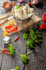 dumplings made of red and white fish meat, in a vintage rustic bowl plate, fork knife spoon, salt,...