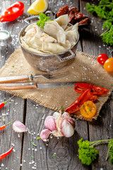 dumplings made of red and white fish meat, in a vintage rustic bowl plate, fork knife spoon, salt,...