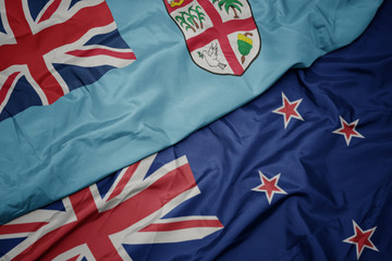 Fototapeta premium waving colorful flag of new zealand and national flag of Fiji.