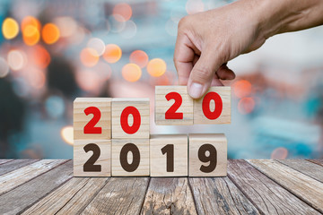 New Year concept from 2019 to 2020, Hand holds cube and changes wooden cubes to Year 2020.