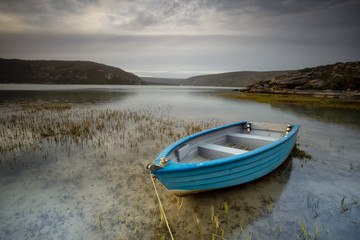 Wide angle landscape image of an old fishing boat in an estuary in South Africa