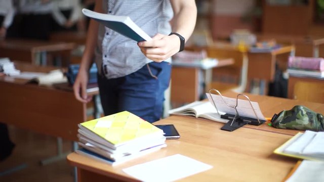 Students write in notebooks. Students use cheat sheets.  Students sit in school.
