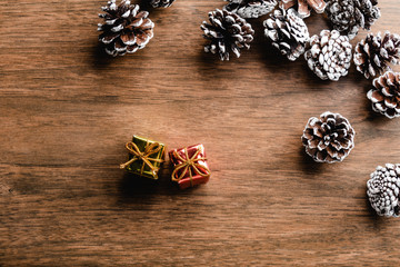 Pine cones on wood background. Christmas decoration with two mini gifts