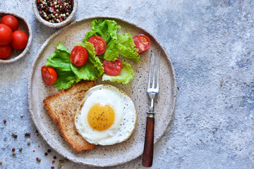 Classic breakfast - bread toast, fried egg and salad. View from above. Good morning.