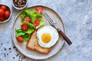 Classic breakfast - bread toast, fried egg and salad. View from above. Good morning.