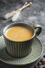 coffee in a mug on a saucer on a gray background, close-up, dark photo, copy space