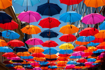 Many colorful umbrellas hanging next to each