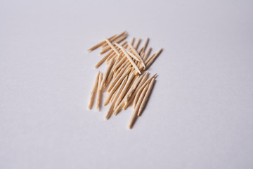 Wooden toothpicks lie in different forms on the table.            