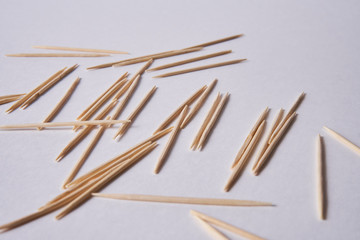 Wooden toothpicks lie in different forms on the table.            