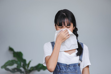 young asian woman got allergy or cold flu illness tissue blowing runny nose