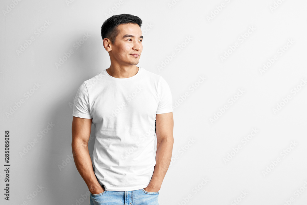 Wall mural portrait of young asian designer dressed in casual against white wall. handsome kazakh man joyfully 