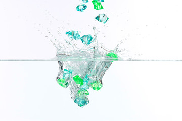 Beautiful and cool splashes of water from falling into it green transparent crystals