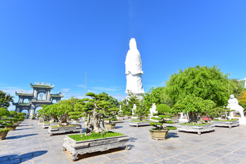 Bonsai Garden with White Guan Yin Statue in the Background in Da Nang City