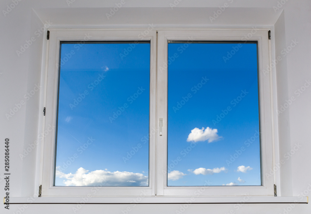 Wall mural view of closed white window overlooking blue sky with clouds, view from home