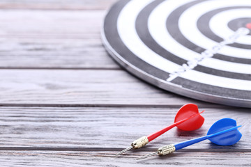 Dartboard with darts on wooden table