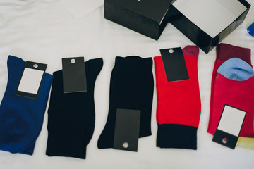 Stylish socks in different colors for groom and his groomsmen best man on bed in hotel room. Morning preparation before wedding ceremony. Men accessory for luxury event