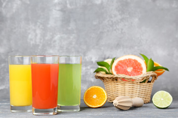 Citrus juice in glasses with fruits on wooden table