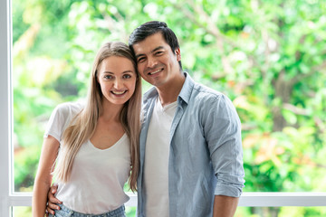 Fototapeta premium Couple portrait with window background. White male and female, hugging.