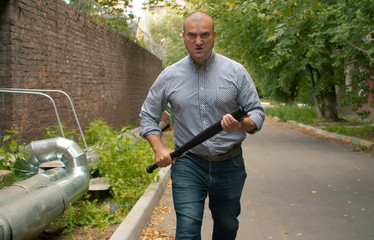 An angry bully with a bat in his hands