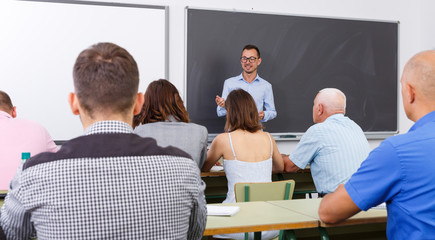 Young lecturer talking to mixed age  students © JackF