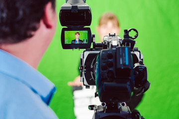 Camera pointed at a news woman or reporter in green room studio