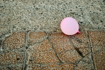 Pink ballon on a stones sidewalk 