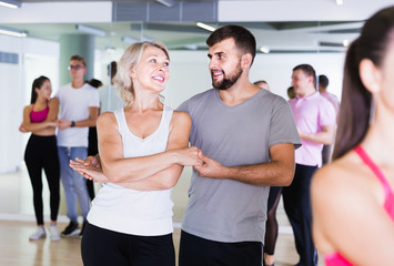   men and women  of different ages dancing salsa in dance hall - obrazy, fototapety, plakaty