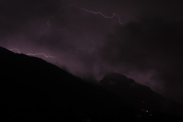 lightnings in the mountains on a black and purple background. Lighting bolt, lightning
