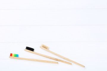 Bamboo toothbrushes on white wooden table