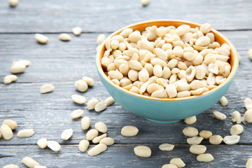 Peanuts in bowl on grey wooden table