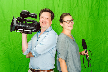 Crew of reporter and cameraman posing in the studio