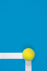 Big tennis ball on blue background In or out challenge hard court