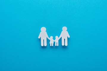 top view of paper cut family holding hands on blue background