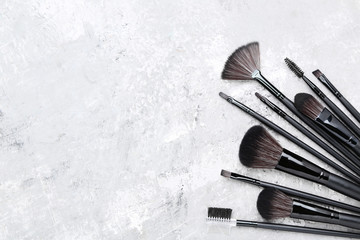 Set of makeup brushes on grey background