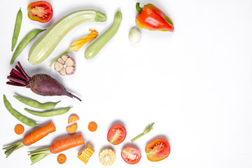 Pattern made of haricot, tomatoes, pepper, corn, onion, red beet, carrot, zucchinion white background . Flat lay, top view, copy space. Healthy eating concept.