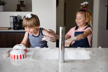 Kids throwing suds while washing dishes