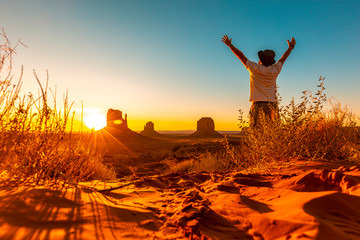 A lifestyle guy with a hat and open arms at dawn in Monument Valley, Utah