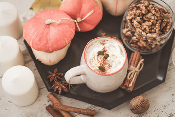 Spicy pumpkin latte coffe, autumn hot drink, with pumpkins, cinnamon and spices on old rustic wooden background copy space. beautiful autumn composition with pumpkins.  Fall season, thanksgiving holid