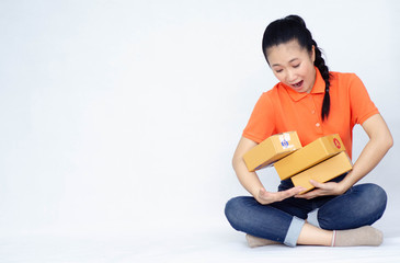 Asian women a orange shirt. she smiled and held several brown boxes at the same time isolated white background.Women send parcels.