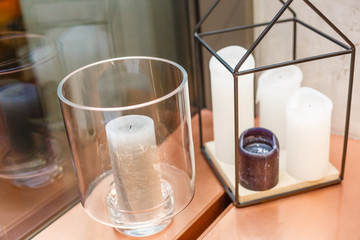 White candles in glass candlesticks. Blurred background