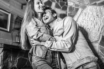 Young and beautiful happy family together in modern interior. Black-white couple portrait.