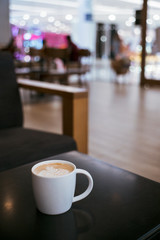 white cup of coffee latte on table in cafe