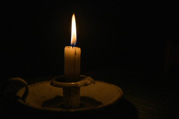 Close up image of a candle burning in a dark room
